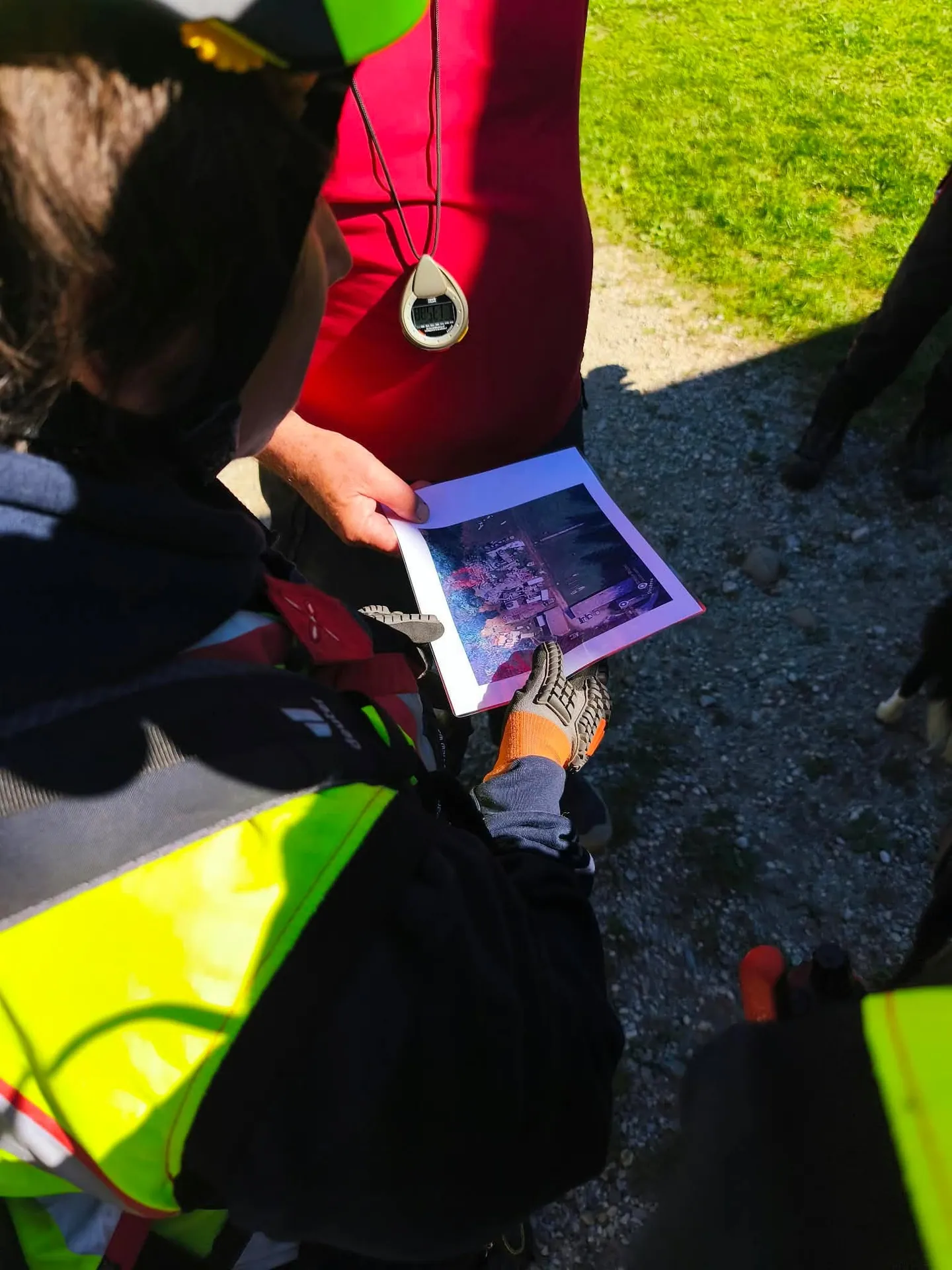 Vodnik pred nalogo pregleduje fotografijo delovišča z ruševinami.