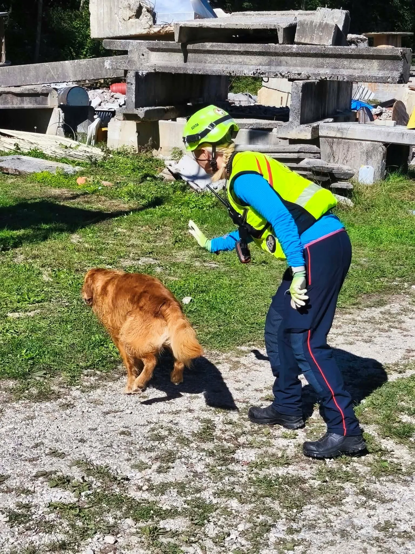 Reševalni par – vodnik in pes – na delovišču z ruševinami.