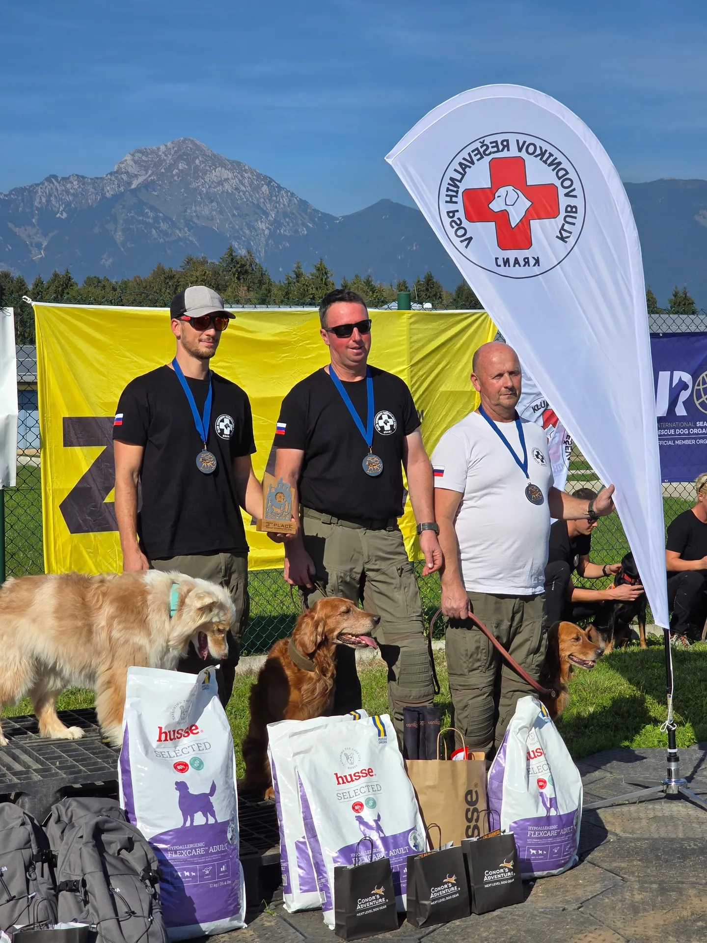 Nagrajena ekipa z medaljami pod zastavo Kluba vodnikov reševalnih psov Kranj.