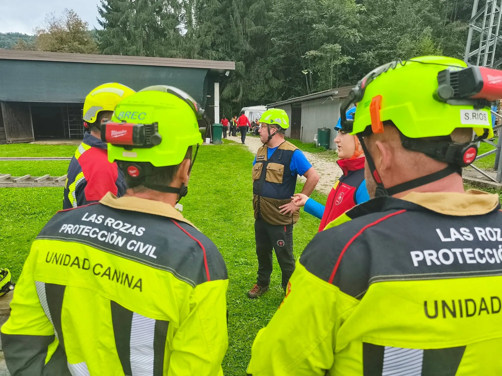 Dva udeleženca se pogovarjata na travniku poligona.