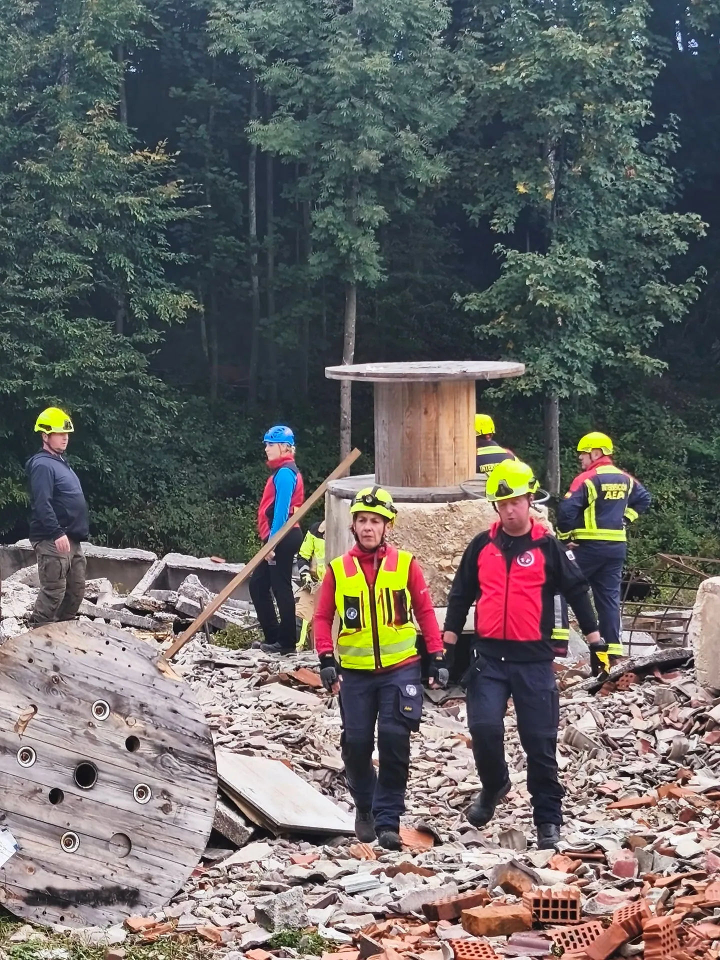 Udeleženci v čeladah na poligonu z ruševinami.
